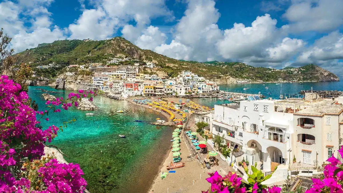 Small tour boat approaching the fishing village of Sant'Angelo on a three-hour boat tour of the island of Ischia, Campania, Italy