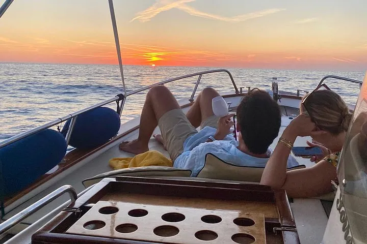 Private gozzo boat anchored at sunset off Forio on a private sunset boat tour in Ischia, Campania, Italy